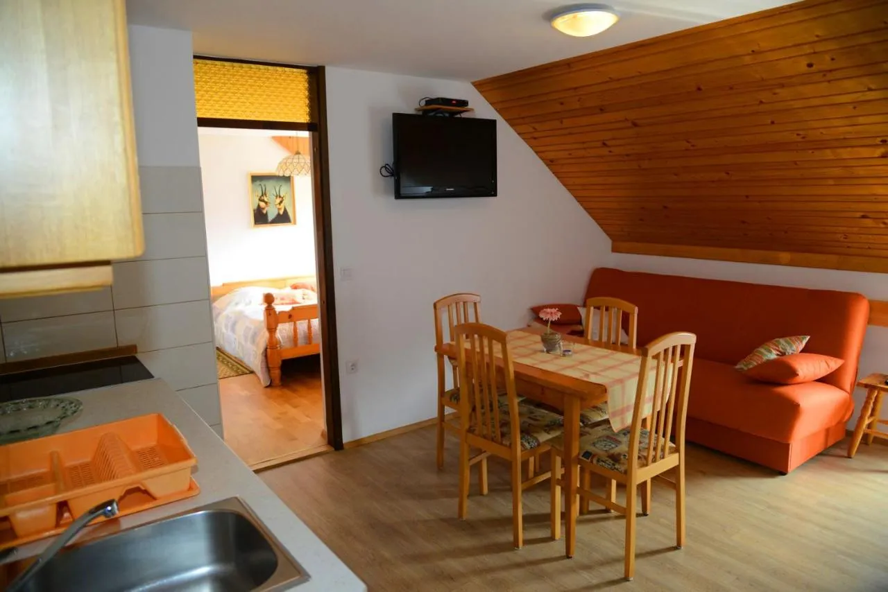Kuhinjski kot z oranžnim kavčem in pogledom v spalnico
