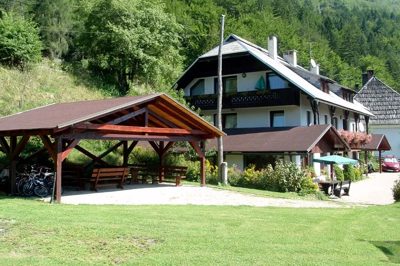 Lesena nadstrešnica s klopmi na vrtu pred hišo